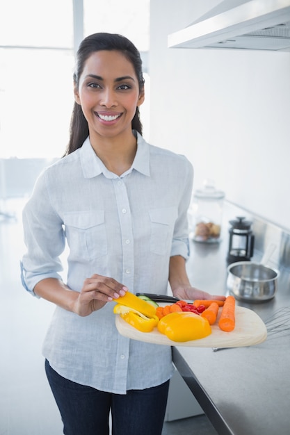 Belle femme fière, montrant des légumes, souriant à la caméra