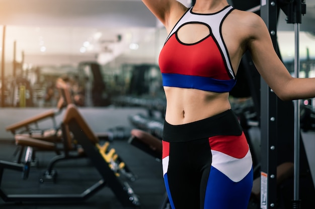 Belle femme fit dans la salle de gym avec intérieur de l&#39;équipement