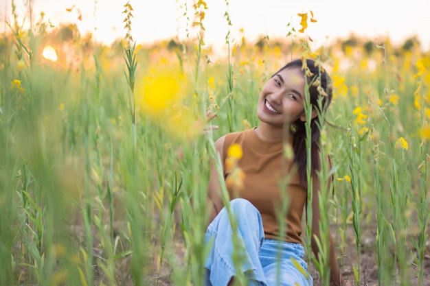 Belle femme avec fleur Crotalaria pendant la soirée