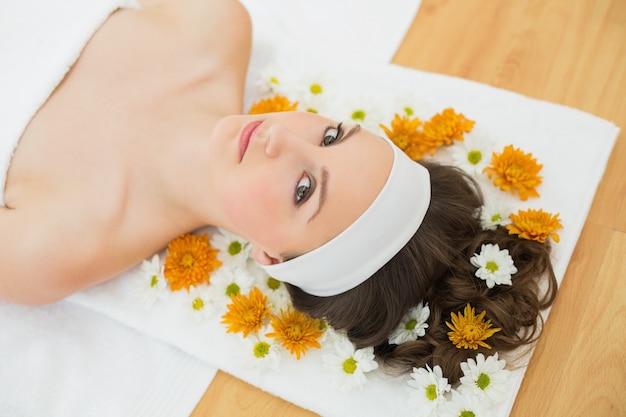 Belle femme avec des fleurs dans un salon de beauté