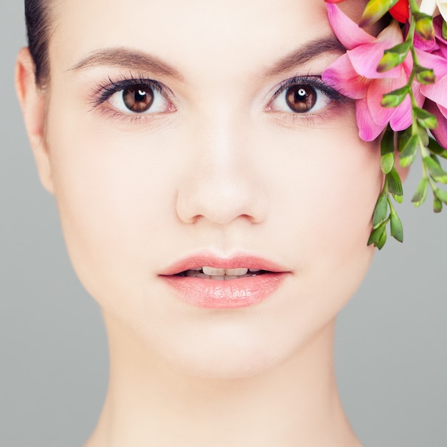 Belle femme avec des fleurs. Gros plan du visage