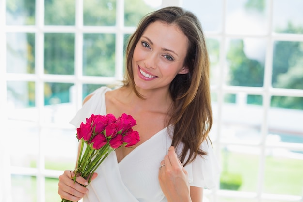 Belle femme avec des fleurs à la maison