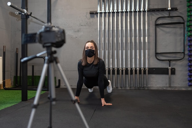 Une belle femme en forme filme une séance d'entraînement devant la caméra