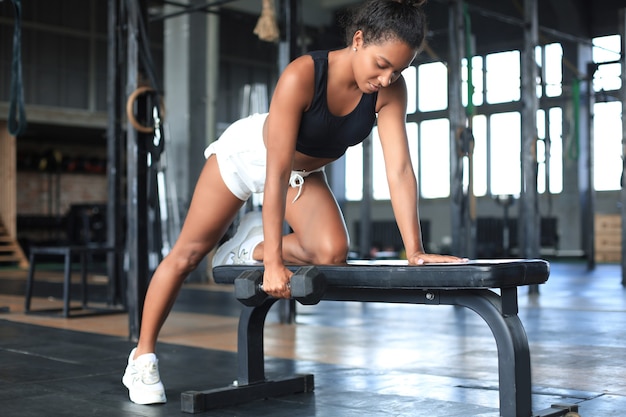 Belle femme en forme musculaire exerçant des muscles de construction.