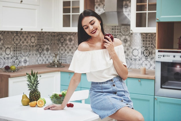 Belle femme avec des fruits d'aliments sains dans la cuisine.