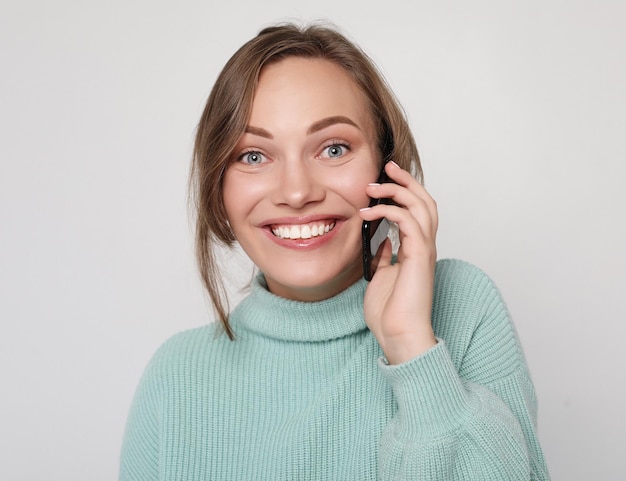 Belle femme gaie parlant au téléphone portable