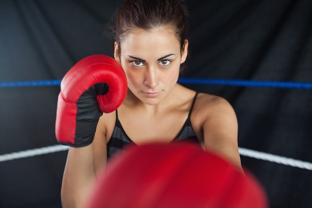 Belle femme en gants de boxe rouges dans le ring