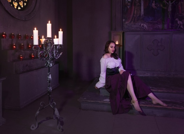 Belle femme gitane en gros plan dans la pièce sombre de l'église cathédrale avec tambourin de musique