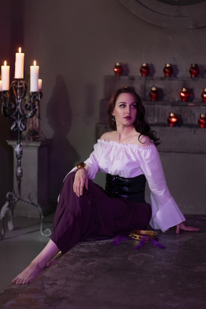 Belle femme gitane en gros plan dans la pièce sombre de l'église cathédrale avec tambourin de musique