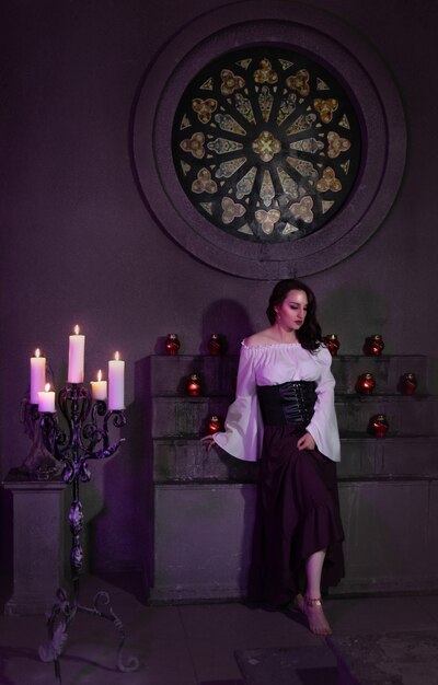 Belle femme gitane en gros plan dans la pièce sombre de l'église cathédrale avec tambourin de musique