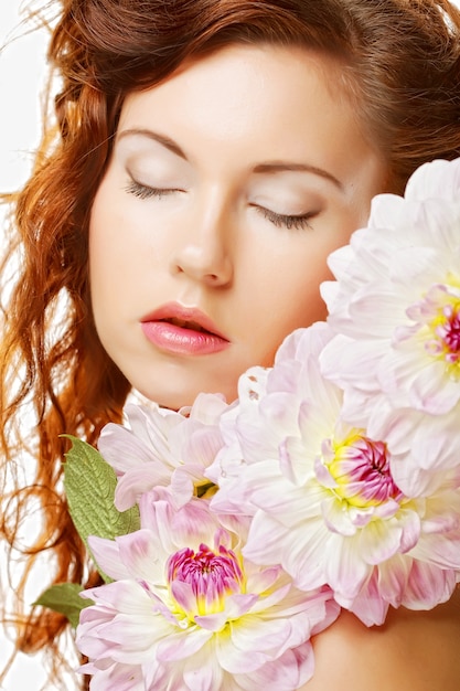 Belle femme avec de grandes fleurs roses