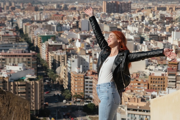 Belle femme heureuse et jeune profite de la vue sur la ville