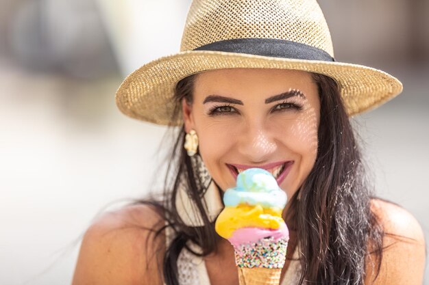 Belle femme heureuse lèche la crème glacée pendant une chaude journée d'été