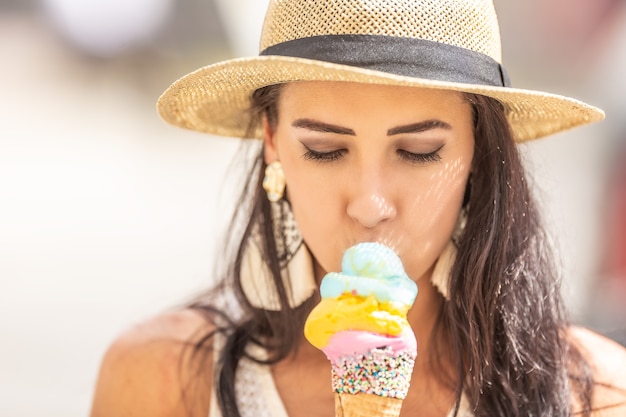 Belle femme heureuse lèche la crème glacée pendant une chaude journée d'été.