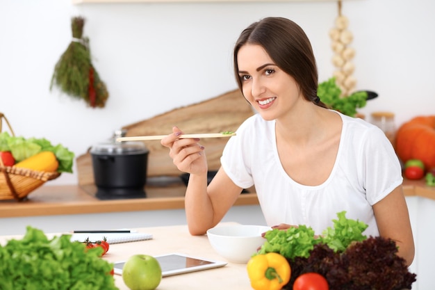 La belle femme hispanique fait cuire dans la cuisine