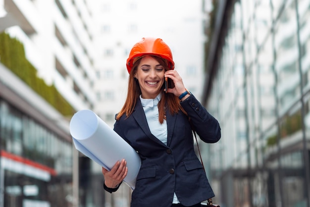 Belle femme ingénieur parlant au téléphone en plein air