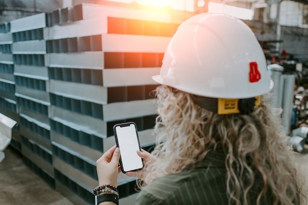 Belle femme ingénieur se lève et prend des photos de l'usine