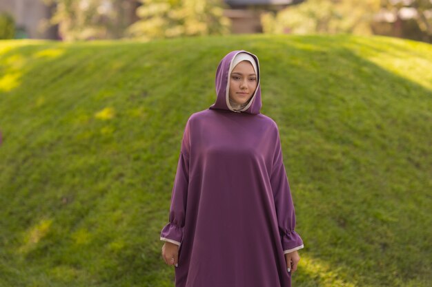 Belle femme islamique dans une robe musulmane debout sur un parc d'été rue fond forêt arbres d'automne. Journée mondiale du hijab.