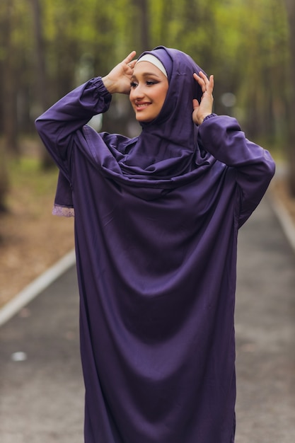 Belle femme islamique dans une robe musulmane debout sur un parc d'été rue fond forêt arbres d'automne. Journée mondiale du hijab.