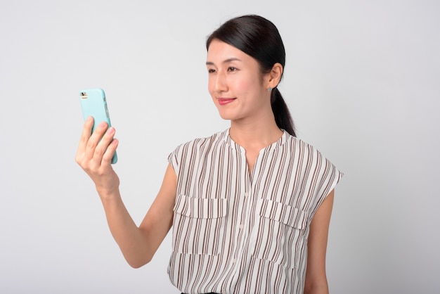 belle femme japonaise contre le mur blanc