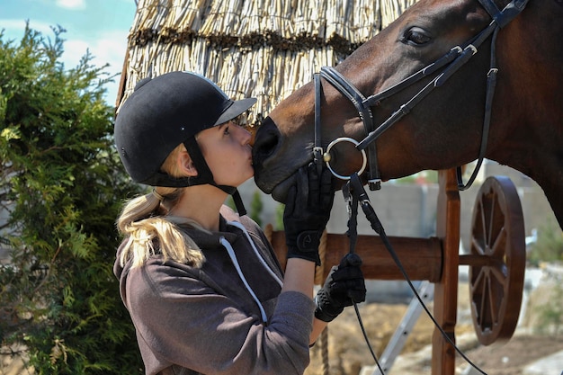 Belle femme jockey embrasse son cheval Tendresse amour et concept d'animaux