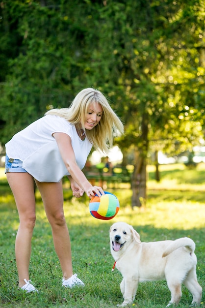 Belle femme jouant avec un chiot labrador