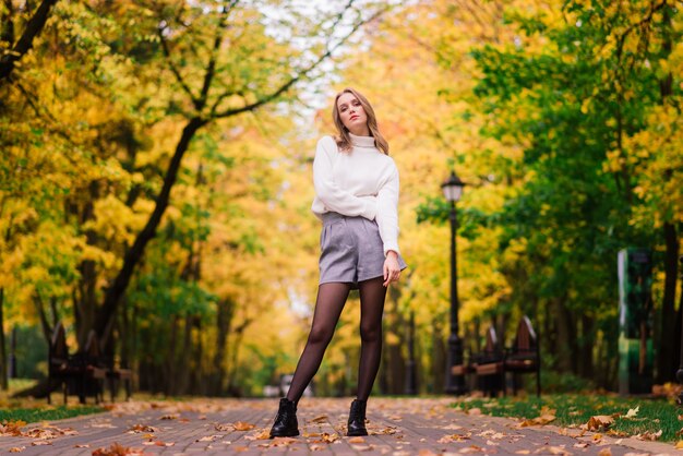 Belle femme jouant de la guitare ukulélé à l'extérieur dans la forêt d'automne