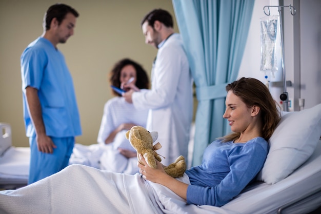 Belle femme jouant avec un ours en peluche