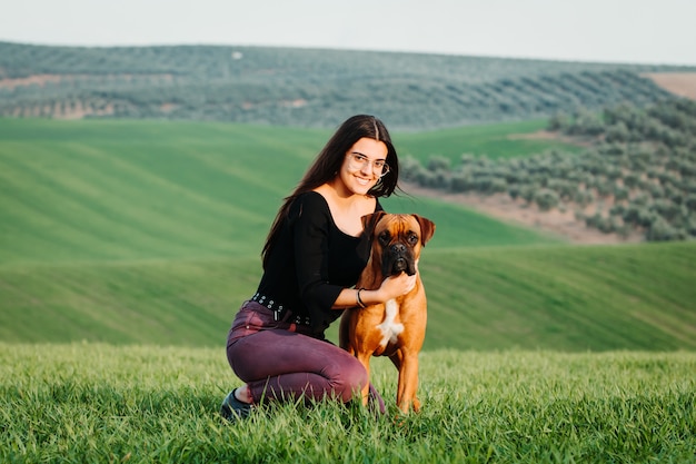 Belle femme jouant avec son chien. Portrait en plein air.