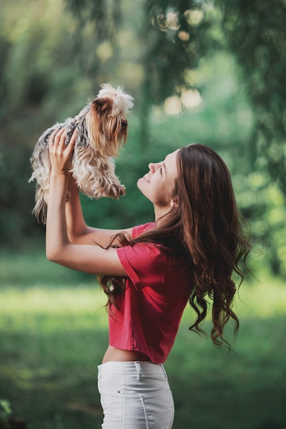 Belle femme joue avec un chien dans le parc