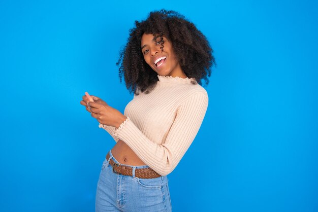 Belle femme joyeuse accro à l'aide d'un gadget jouant à un jeu en réseau