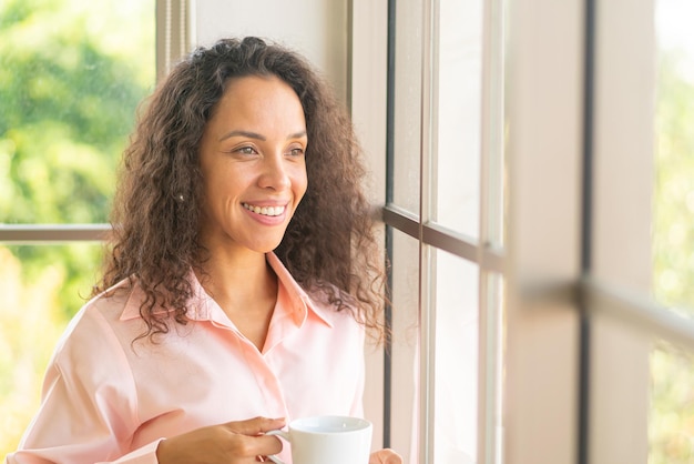 belle femme latine buvant du café le matin