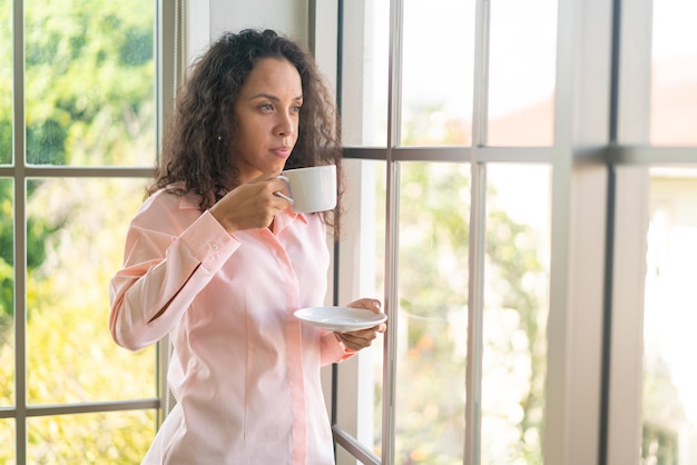 Belle femme latine buvant du café le matin