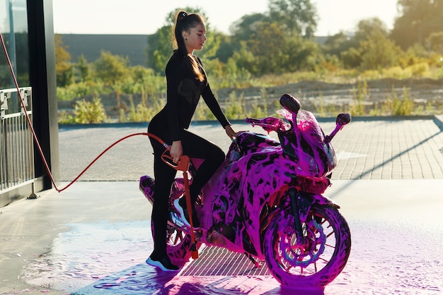 Belle femme lave une moto