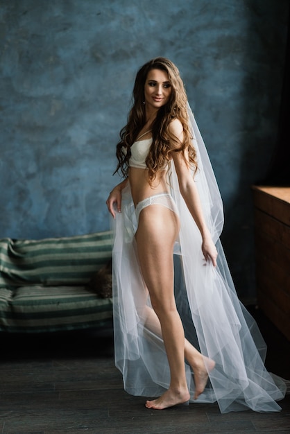 Belle femme en lingerie blanche et un voile