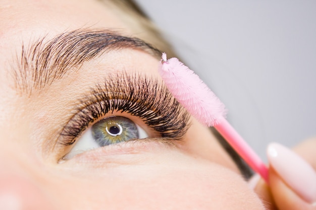 Belle femme avec de longs cils dans un salon de beauté. Extension de cils.