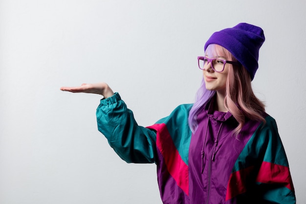 Belle femme à lunettes et combinaison de sport des années 80 sur fond blanc