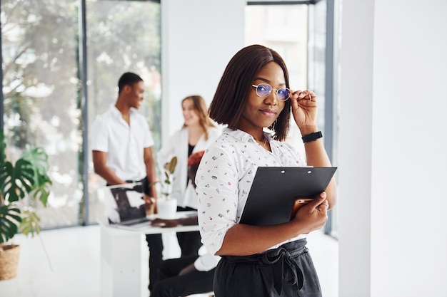 Belle femme à lunettes devant ses collègues Groupe de gens d'affaires afro-américains travaillant ensemble au bureau