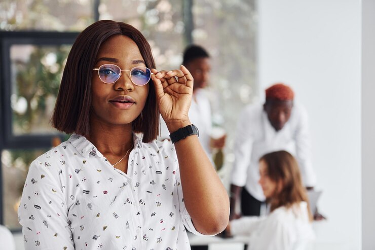 Une belle femme en lunettes devant ses collègues un groupe d'hommes d'affaires afro-américains travaillant ensemble au bureau