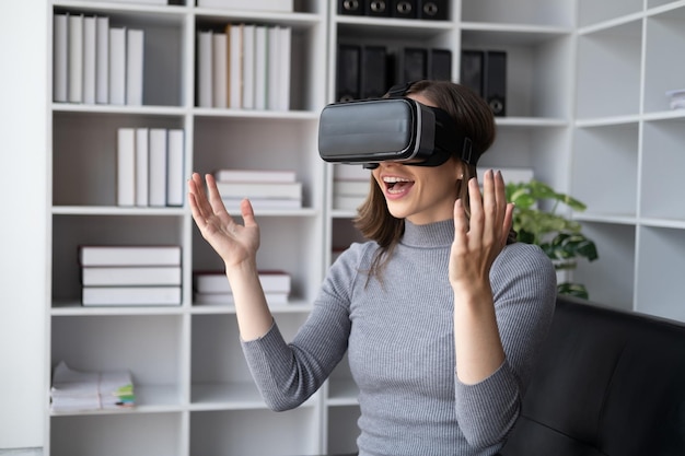 Une belle femme avec des lunettes de réalité virtuelle qui s'amuse à la maison.