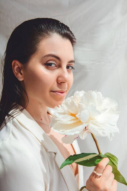 Belle femme magnifique avec des fleurs de pivoines. fermer