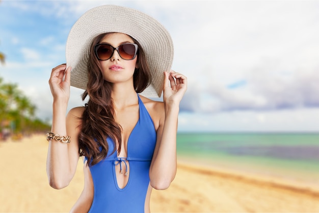 Belle femme en maillot de bain bleu sur fond de mer tropique