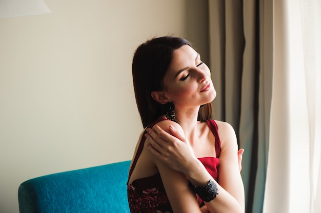 Belle femme à la maison près de la fenêtre