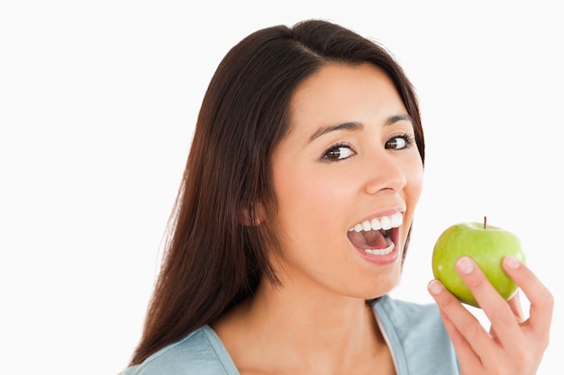 Belle femme mange une pomme verte