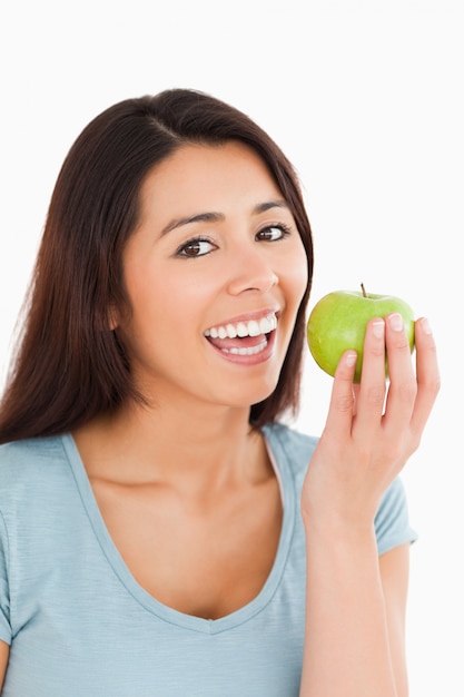 Belle femme mange une pomme verte