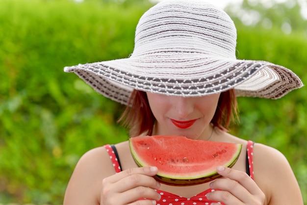 Belle femme mangeant une pastèque