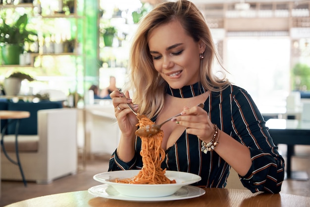 Belle femme mangeant des spaghettis