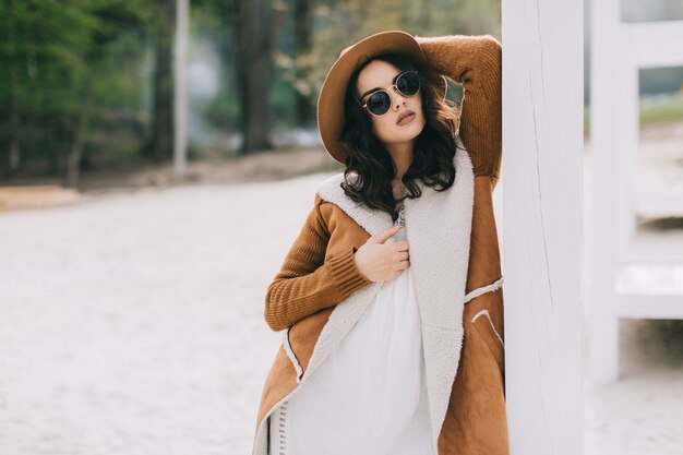 Belle femme en manteau et lunettes de soleil