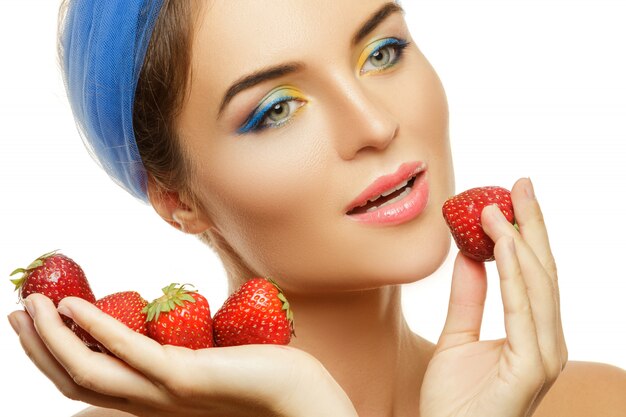 Photo belle femme avec maquillage coloré et fraise