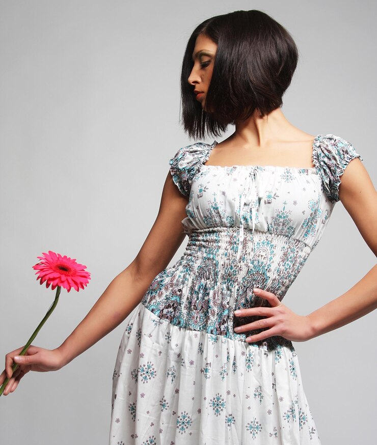Photo belle femme avec un maquillage lumineux tenant une fleur de gerber rose